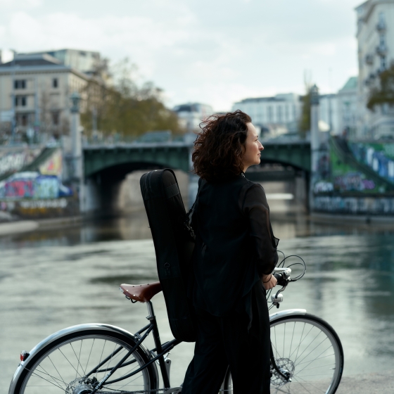 Musikerin mit Fahrrad am Donaukanal
