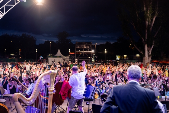 Konzertbühne mit Musikern, davor das Publikum 