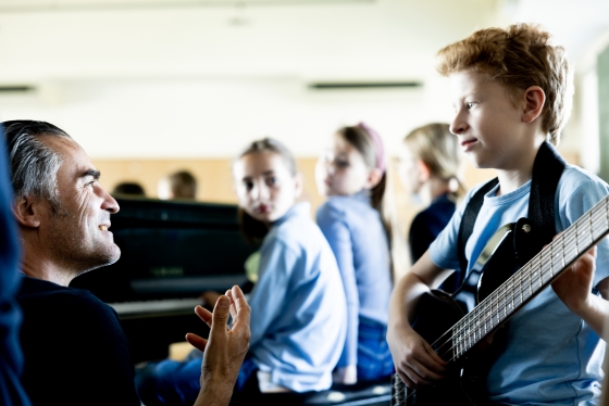 Bub mit Gitarre und Mädchen am Klavier