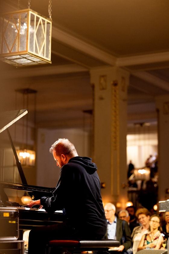 Pianist auf der Bühne im Konzerthausfoyer vor Publikum 