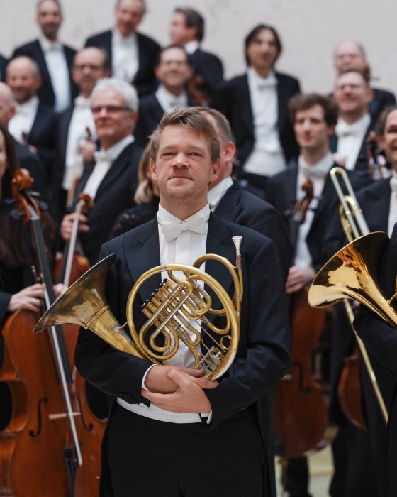 Hornist vor anderen Orchestermusikern