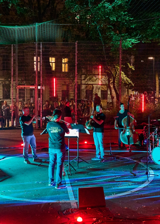 Eine Band musiziert nachts im Spielkäfig