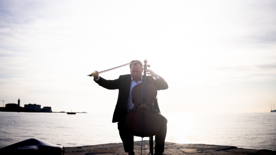 Cellist spielt im Sonnenuntergang am Molo Audace