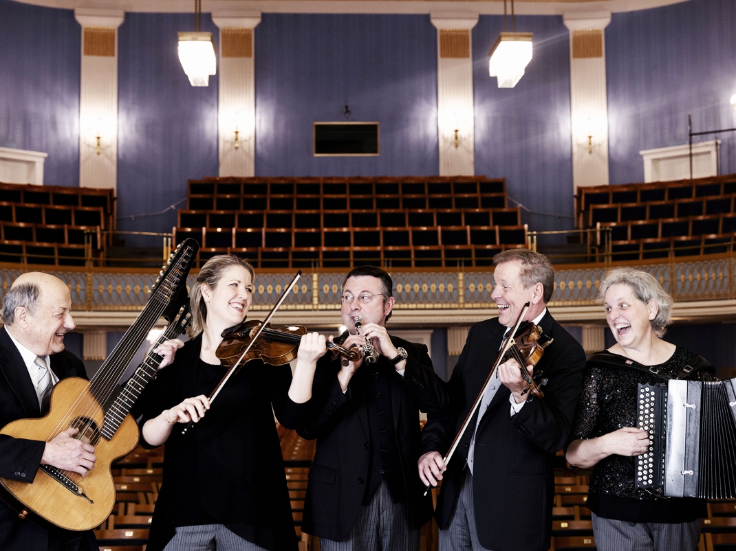 Fünf Musiker:innen des Schrammelquintetts mit ihren Instrumenten