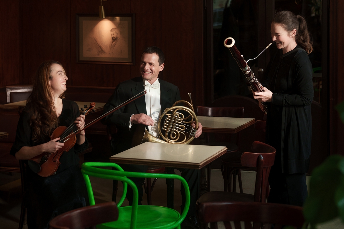 Drei Musiker:innen mit Instrumenten im Wiener Café