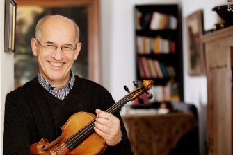 Foto von Guillermo Büchler an einem Streichinstrument in der Hand